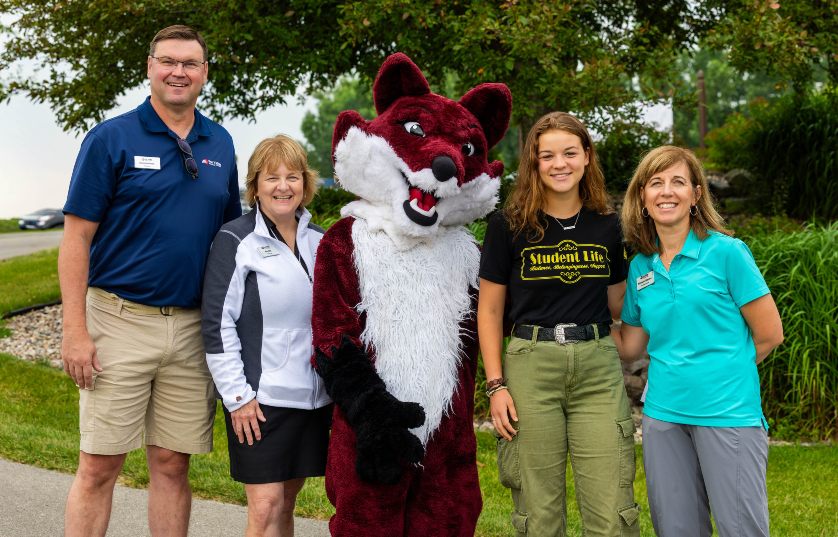 Group of people standing with the FVTC Fox mascot smiling at the camera